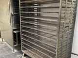 a large metal rack with many trays of food in it