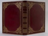 un vieux livre à la couverture rouge et à la bordure dorée