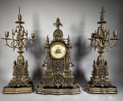 Trois horloges anciennes sont posées les unes à côté des autres sur une table