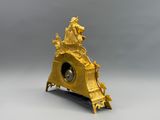 une image représentant une horloge dorée posée sur une table