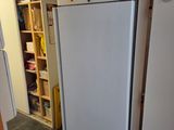 a white refrigerator in a kitchen next to a book shelf