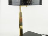 a black table lamp with a gold base and a black shade