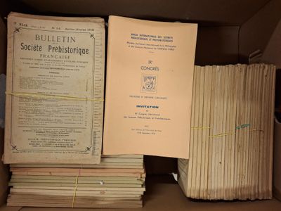 plusieurs livres sont empilés dans une boîte