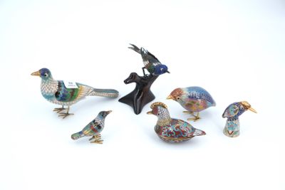 five figurines of birds sitting on a white surface