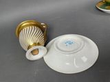 a cup and saucer sitting on a table next to a saucer