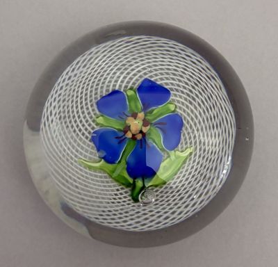 a glass bowl with a blue flower inside of it