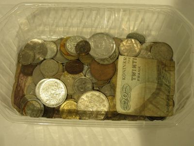 un récipient en plastique rempli de pièces de monnaie et un livre