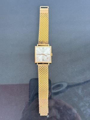 yellow gold tone watch with a mesh band