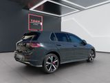 the rear view of a grey volkswagen golf r - line in a showroom