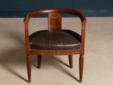 an image of a wooden chair with a leather seat on a carpeted floor