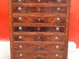 a wooden chest of drawers with metal handles and knobs