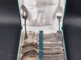silverware in a green case with spoons and spoons in it