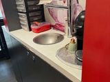 a small kitchen with a sink and a red wall