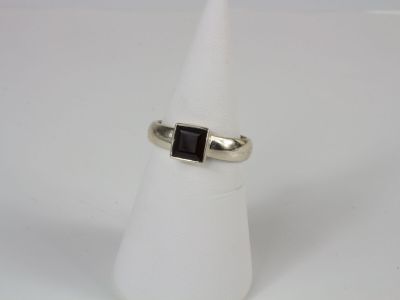 a silver ring with a black stone in the middle