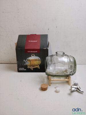 a small glass bottle with a cork stopper next to a box