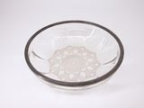 un bol en verre orné d'un motif, posé sur une surface blanche