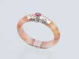 un gros plan d'une bague sertie d'une pierre rose