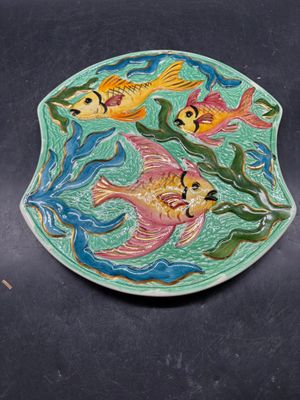une assiette ornée d'un motif de poisson, posée sur une table