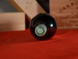 a black pool ball on a red table with a wooden box in the background