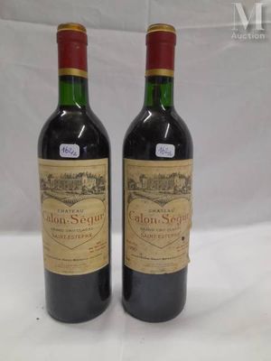 two bottles of red wine sitting next to each other on a table