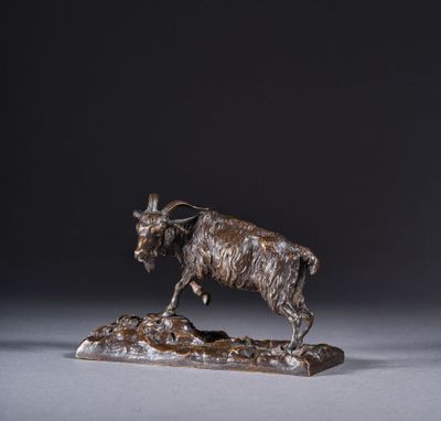une statue en bronze représentant une chèvre debout sur un rocher