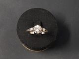 a close up of a diamond ring on a black ring holder