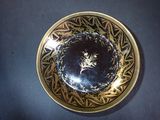 a gold plate with a black and white design on it