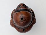 a small wooden object that is on a white surface