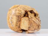 a small wooden skull sitting on a white table