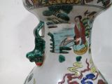 un vase avec un tableau posé sur une table