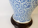un vase bleu et blanc posé sur un socle en bois