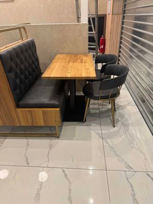 une table, deux chaises et un banc dans une pièce