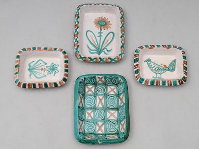 quatre pièces de poterie ornées de motifs, posées sur une table