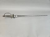 an old sword is laying on a white surface