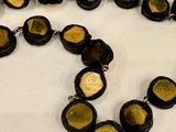 a long necklace with black and gold beads on a table