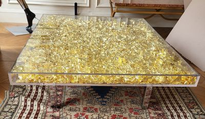 une table basse en verre ornée d'un motif à la feuille d'or