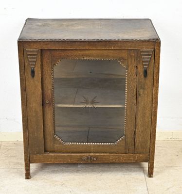 un vieux meuble en bois surmonté d'une porte en verre
