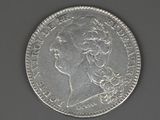 a close up of a coin with a woman ' s face on it