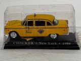 a yellow taxi cab in a glass case on a black base