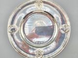 an antique silver plate with a picture of a man holding a camera