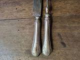 two forks and a knife on a wooden table