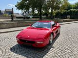 une voiture de sport rouge garée dans une rue pavée