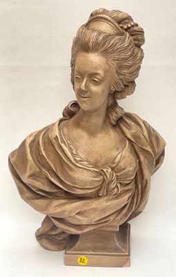 bronze bust of a woman in a dress on a stand