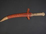a close up of a knife with a wooden handle on a black surface