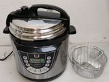 an electric pressure cooker sitting on a counter next to a wire basket