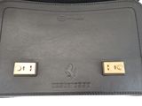 black leather purse with two gold buttons on the front