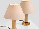 pair of brass table lamps with linen shades on a white surface