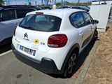 a small white car parked on the side of the road
