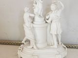 a white statue of a group of people on a pedestal