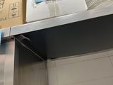 boxes are stacked on top of a metal shelf in a kitchen
